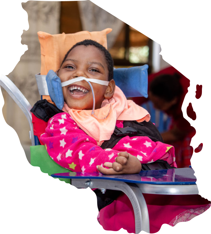 A child smiling in a photo shaped like the map of Tanzania